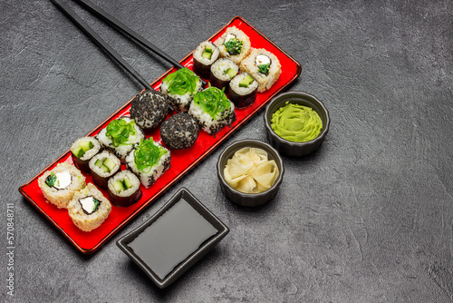 Different types of sushi on a red plate.