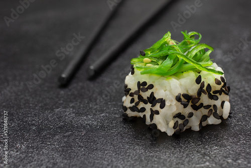 Sushi with green algae. Food sticks. Close up.
