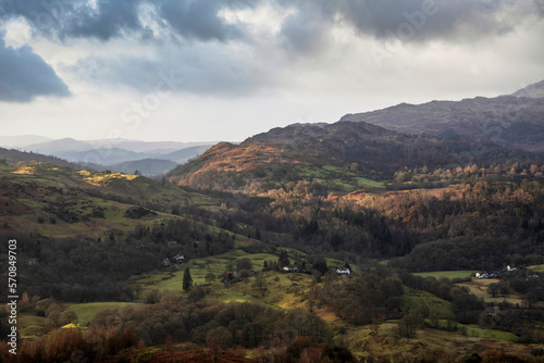 Stunning colorful Winter sunrise golden hour landscape view from Loughrigg Fell across the countryside in the Lake District