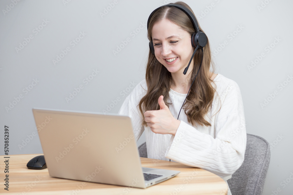 beautiful girl works at home with laptop in white sweater and shows like beautiful girl works at home with laptop in white sweater and shows like