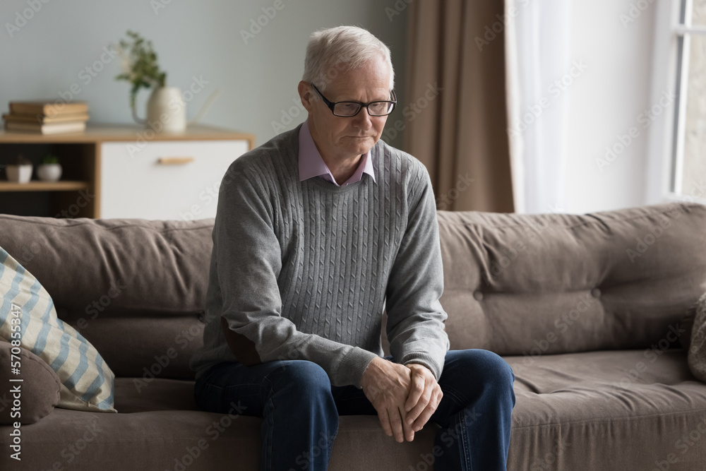 Sad depressed elderly man feeling lost, lonely at home, getting mental Alzheimer disease, memory loss, sitting on sofa at home looking into vacancy with bad thoughts, thinking on problems Sad depressed elderly man feeling lost, lonely at home, getting mental Alzheimer disease, memory loss, sitting on sofa at home looking into vacancy with bad thoughts, thinking on problems