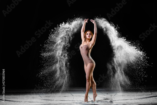 Young slim woman with spread flour on the air