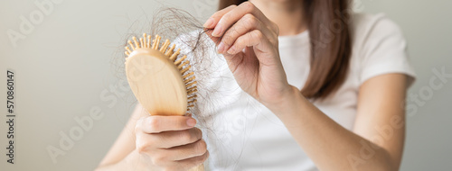 Wallpaper Mural Serious asian young woman holding brush holding comb, hairbrush with fall black hair from scalp after brushing, looking on hand worry about balding. Health care, beauty treatment, hair loss problem. Torontodigital.ca