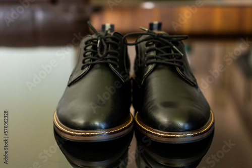 Front view of black formal leather shoes on a black floor. Mens formal shoes