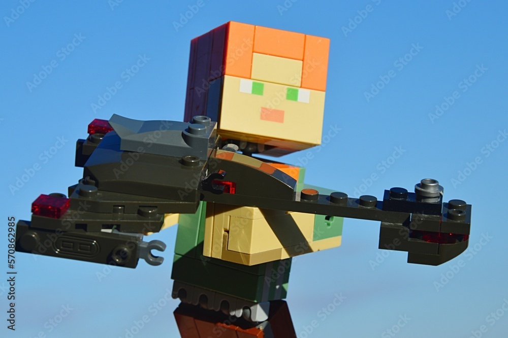 Fototapeta premium LEGO Minecraft large figure of Alex showing KREO model of Klingon Bird Of Prey, assault spaceship from Star Trek TV and movie series. Blue skies in background.