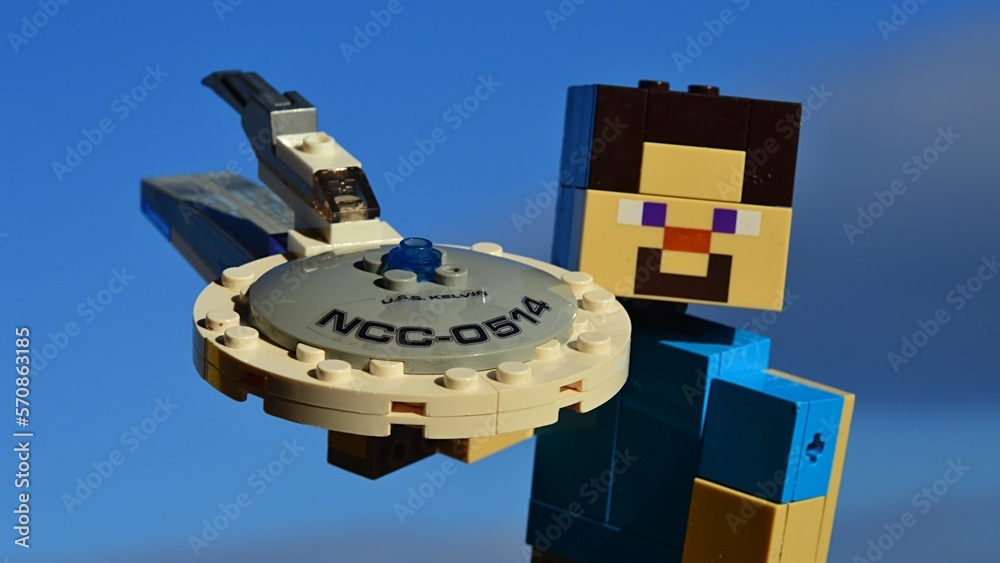 Obraz premium LEGO Minecraft figure of Steve showing front side of model of Star Trek spaceship USS Kelvin by KREO with modified top, winter partially cloudy skies in background. Morning sunlight.