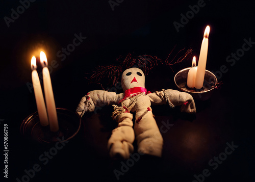 A voodoo ritual with a creepy handmade rope doll, symbolizing the victim to be nailed and hurt, surrounded by lit candles. Generative AI illustration.
 photo