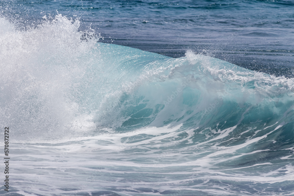 close-up of a wave breaking against the shoreline and creating lots of white foam. Tenerife, Canary Islands, Spain