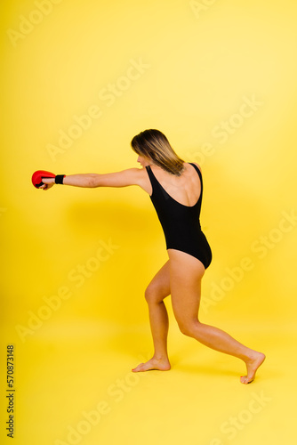 Woman do high kick, tae-bo. Athletic fit female with perfect body kick air, punching with legs