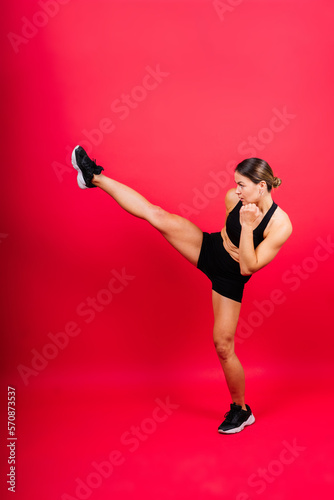Woman do high kick, tae-bo. Athletic fit female with perfect body kick air, punching with legs