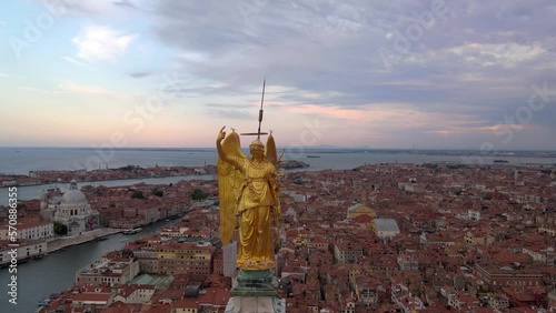 Statue of the archangel Gabriel on top of St Mark's, Venetian lagoon, aerial view in Venice, Italy, 4k video