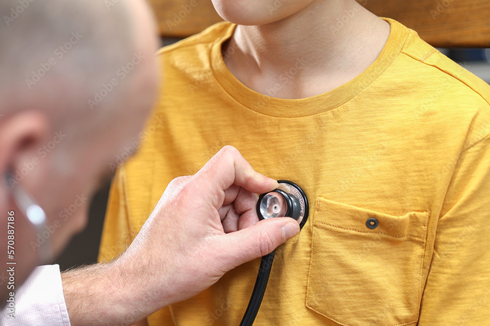 Fototapeta premium Closeup hand of Caucasian male pediatrician use stethoscope do pediatric checkup examination on child boy patient to check heart lungs, children medical care concept. 