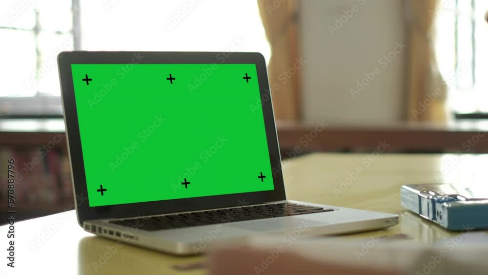 Chroma key green screen laptop computer set up for work on wooden desk with boy doing homework background, mock up, technology concept, zoom in. Chroma key green screen laptop computer set up for work on wooden desk with boy doing homework background, mock up, technology concept, zoom in.