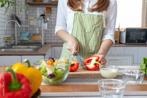 A young woman prepares bell peppers for her breakfast and is ready for a healthy meal on the table with healthy, organic vegetables on the table. healthy food preparation ideas
