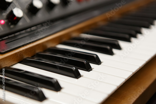 Black and white piano keys on modern synthesizer. Professional electronic synth device in sound recording studio