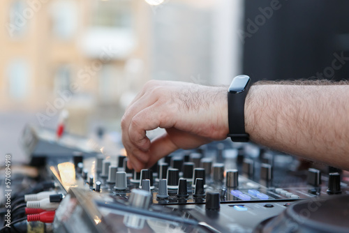 DJ mixing music with sound mixer. Disc jockey plays set at day in a bar with professional audio equipment