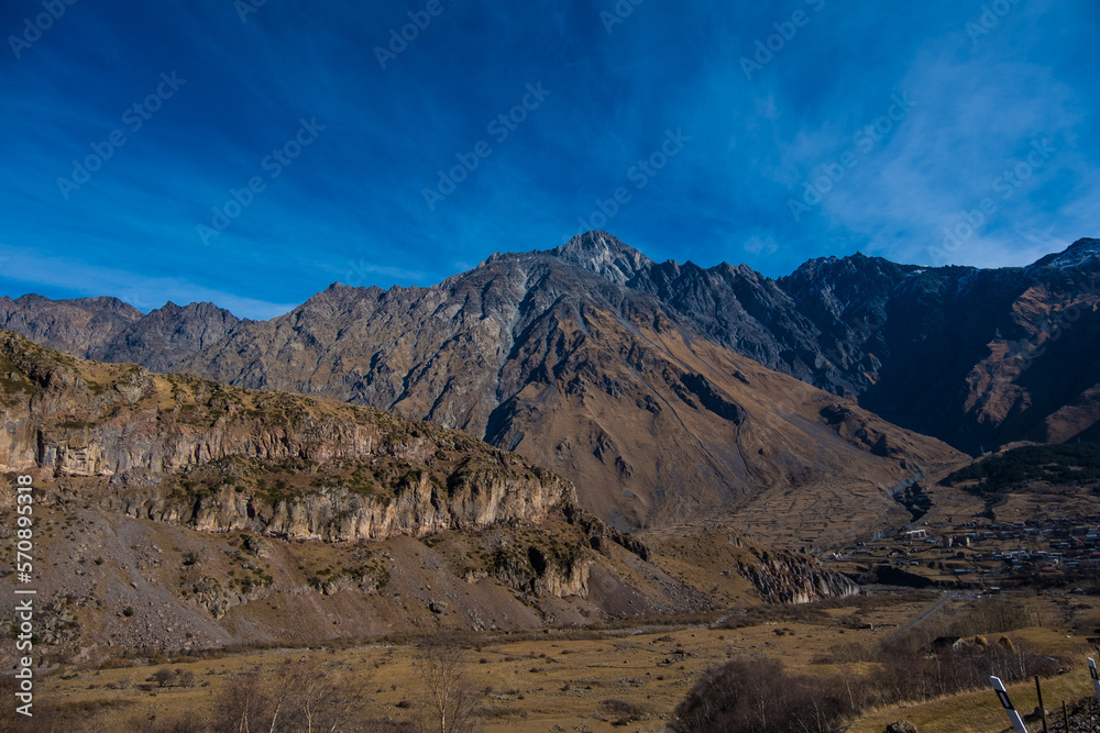 Georgia : 10-11-2022 : Country of Georgia, Kazbegi, Panoramic landscape of beautiful natural mountains, view of amazing Caucasus mountain peaks and meadows in Kazbegi national park