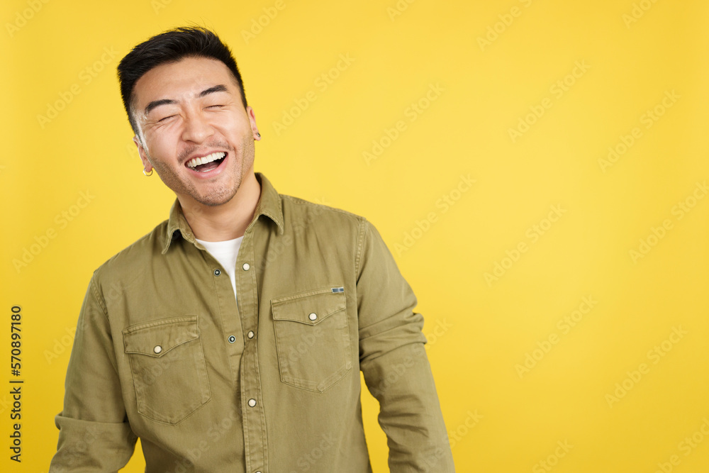 Obraz premium Chinese man laughing with eyes closed while standing