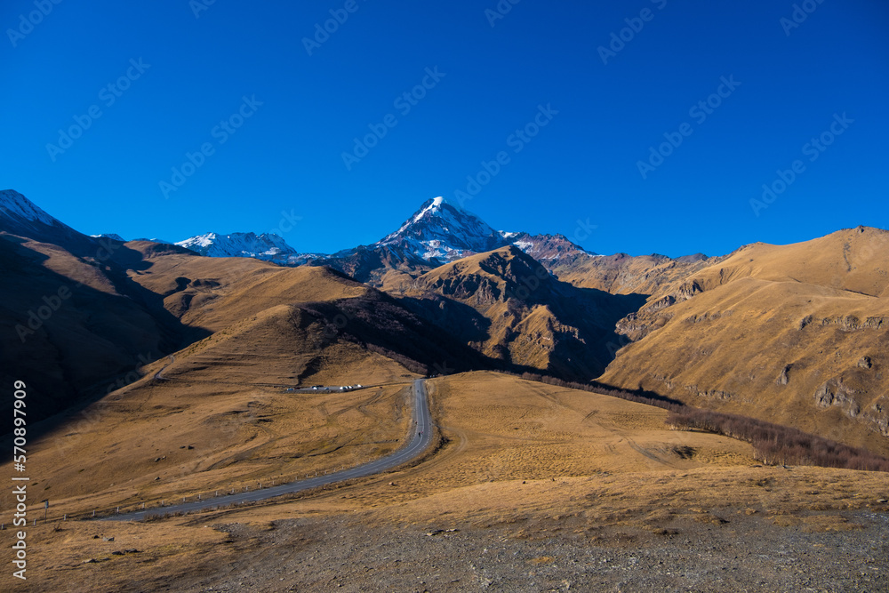 Fototapeta premium Georgia : 10-11-2022 : Country of Georgia, Kazbegi, Panoramic landscape of beautiful natural mountains, view of amazing Caucasus mountain peaks and meadows in Kazbegi national park