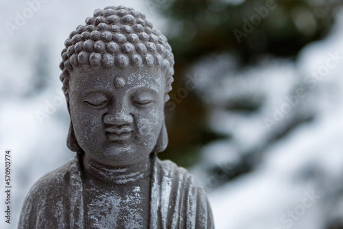 stone buddha statue with snow in the background. concept for meditation and mindfulness