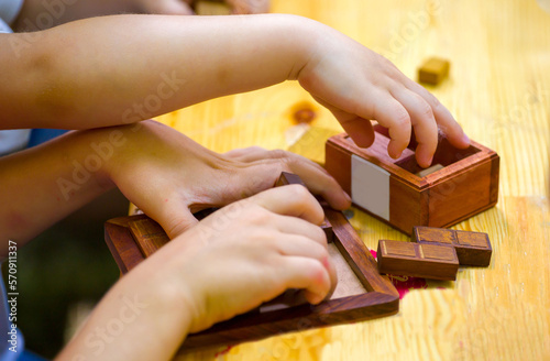 close-up of a child's hand building a pyramid of wooden cubes