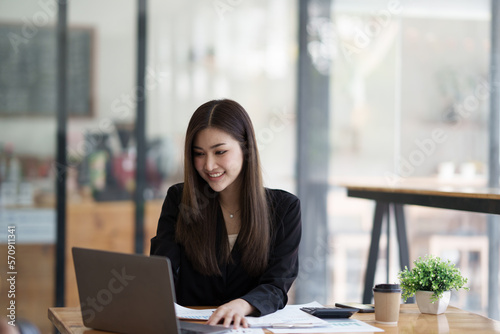 Portrait of young Asian businesswoman working with laptop computer in the office room.