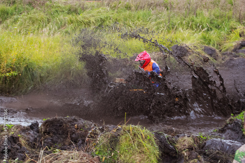 athlete on a quad bike rides in the mud