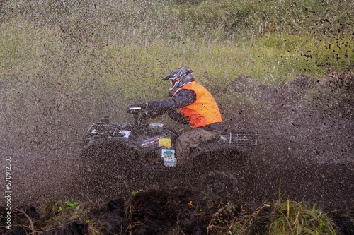 athlete on a quad bike rides in the mud