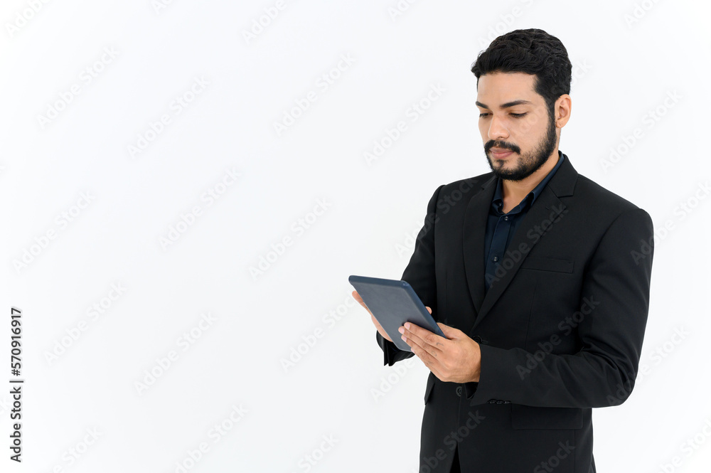 portrait of cheerful attractive young businessman standing and using digital tablet isolated over white background. portrait of cheerful attractive young businessman standing and using digital tablet isolated over white background.