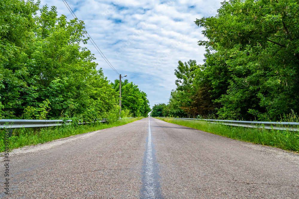 Fototapeta premium Beautiful empty asphalt road in countryside on colored background