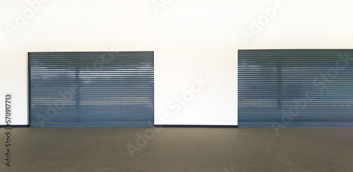 Two closed gray stainless steel windows or grey door shutters in warehouse or cargo terminal. Building and Exterior design for access or entrance.