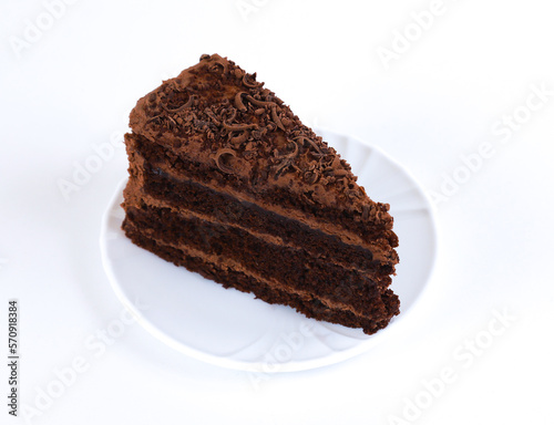 A piece of chocolate cake on a white background. Shallow depth of field
