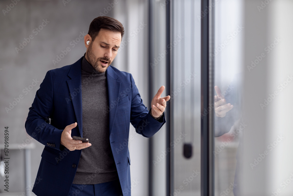Young businessman with mobile phone at workplace