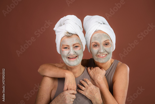 Portrait of happy senior friends with face-mask, selfcare and skin routine concept.