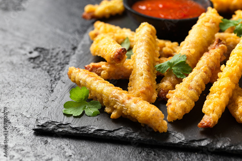 Fried Vegan jackfruit and oyster prawns in crispy batter served on black slate with chili dip sauce