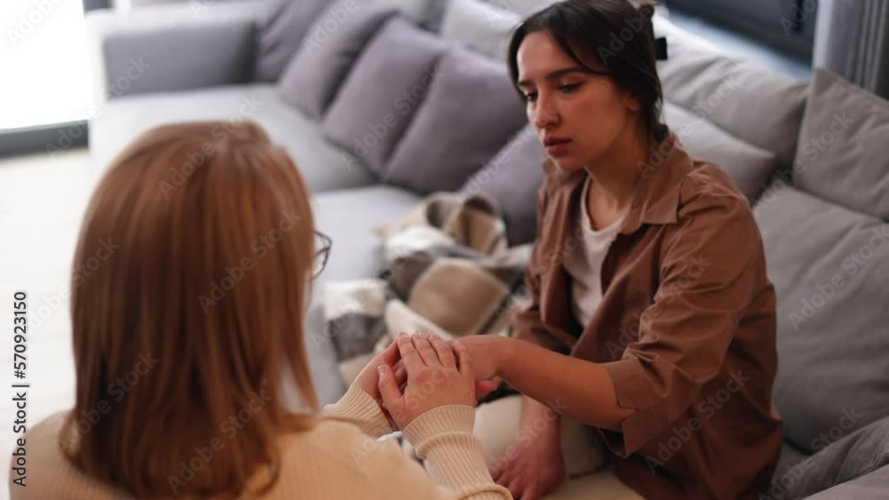 A cute girl at a psychologist's appointment. Psychologist woman holding her patient's hands. Family problems, teenage troubles. Talking with a therapist, advice, help concept. A cute girl at a psychologist's appointment. Psychologist woman holding her patient's hands. Family problems, teenage troubles. Talking with a therapist, advice, help concept.
