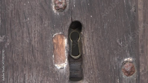 Looking through key hole of an old door from a church spy in UK 4K