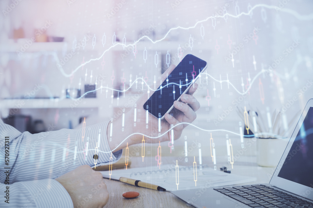 Double exposure of man's hands holding and using a digital device and forex graph drawing. Financial market concept. Double exposure of man's hands holding and using a digital device and forex graph drawing. Financial market concept.