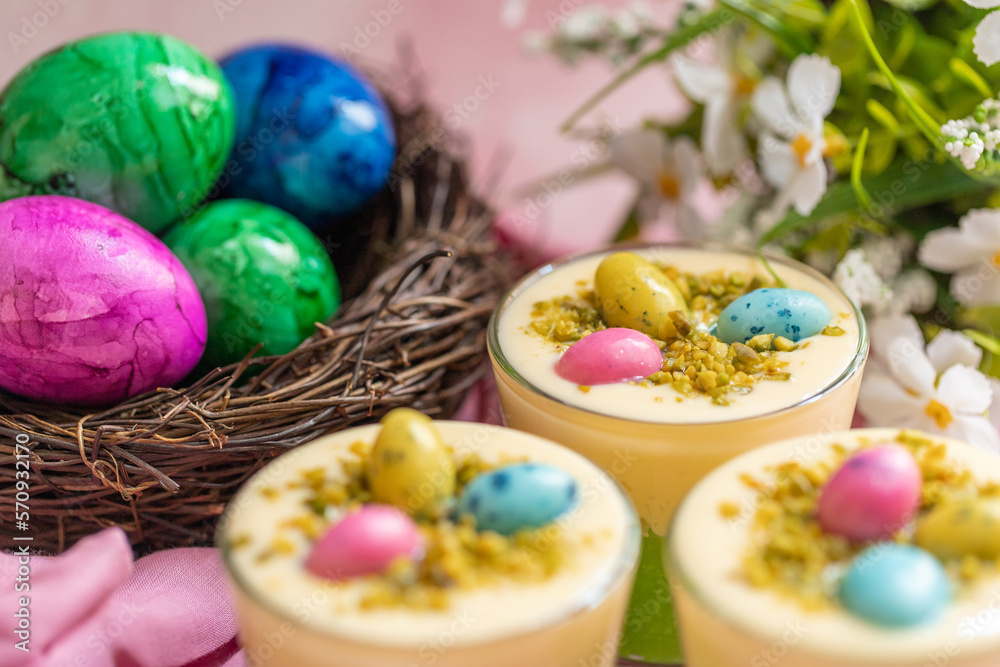 Osternest im Glas geschichtet als Dessert zu Ostern auf rosa Hintergrund Osternest im Glas geschichtet als Dessert zu Ostern auf rosa Hintergrund