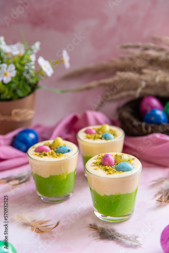 Osternest im Glas geschichtet als Dessert zu Ostern auf rosa Hintergrund