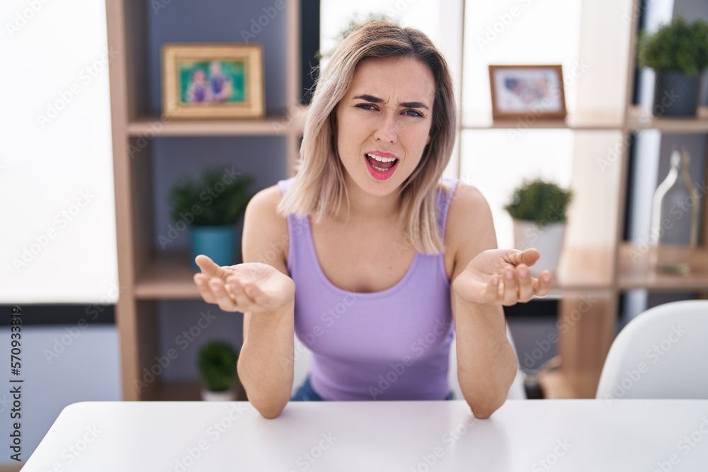 Young woman speaking with unhappy expression at home Young woman speaking with unhappy expression at home
