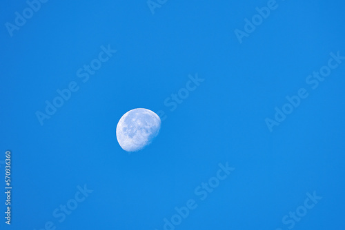 Waning moon in the morning blue cloudless sky