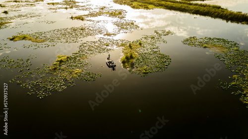 Bass fisherman fishing grass and lilly pads in Florida at sunrise