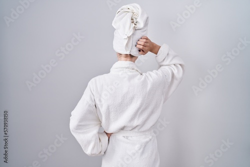 Canvas Print Blonde caucasian woman wearing bathrobe backwards thinking about doubt with hand