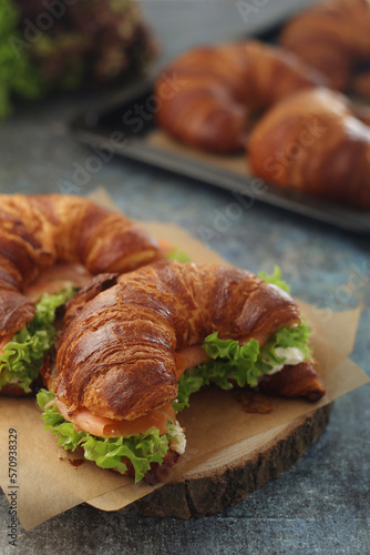 Freshly baked croissants with salmon and salad on the table 