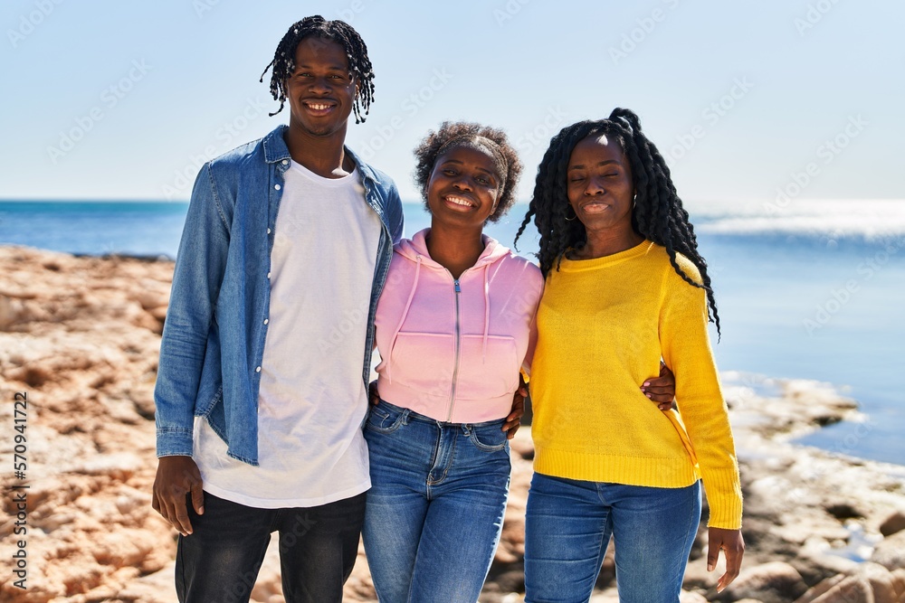 African american friends smiling confident hugging each other at seaside