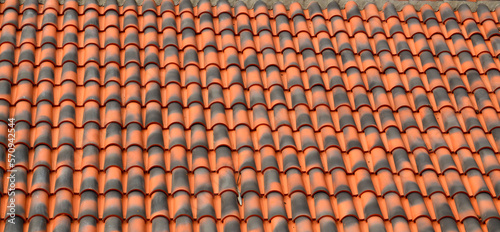 Red brown ceramic tile texture background.Roof of a house with modern shingles.Selective focus.