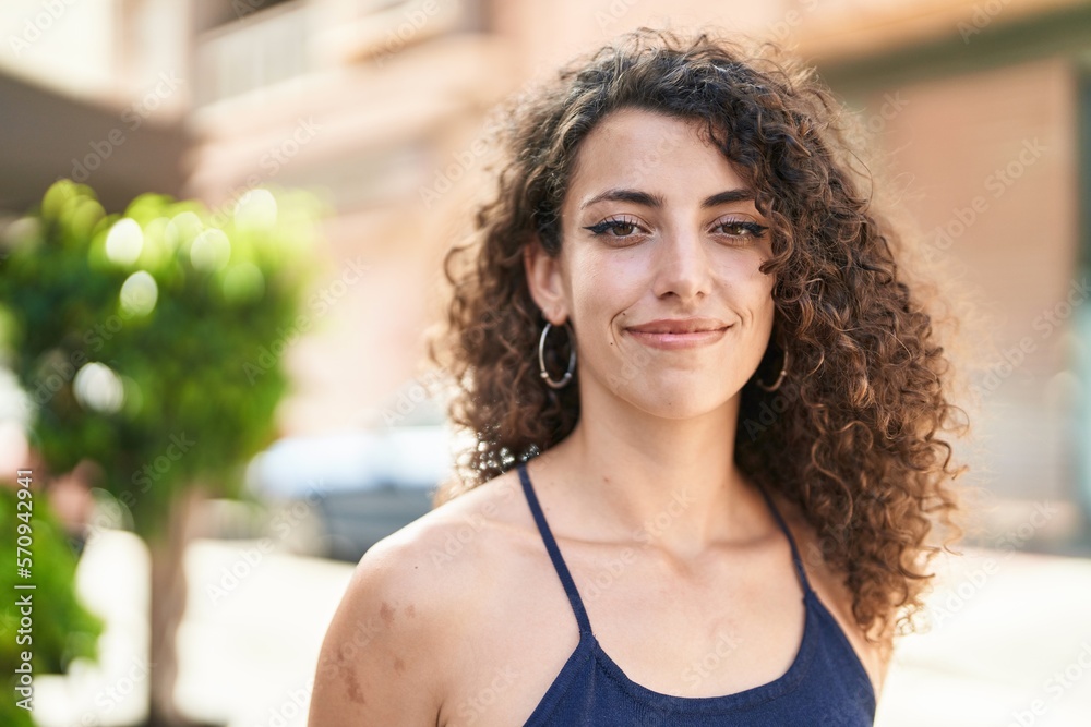 Fototapeta premium Young beautiful hispanic woman smiling confident standing at street