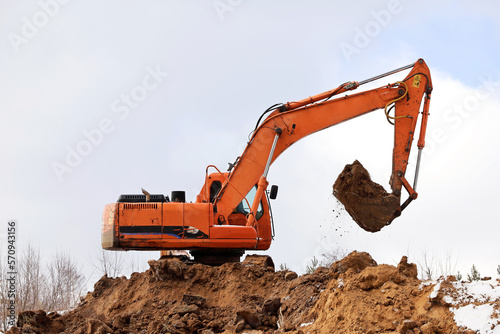 Crawler excavator scoops the earth with a bucket. Earthmoving works, digging on a construction site