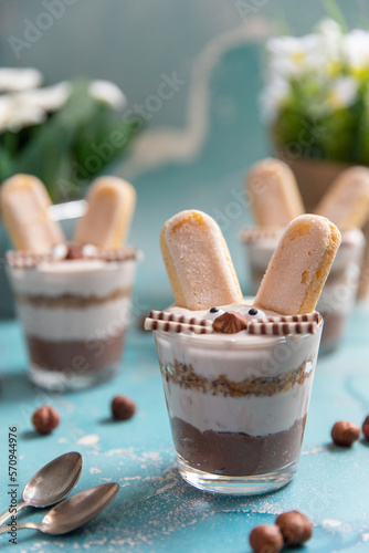 Hase im Glas geschichtet als Dessert zu Ostern auf blauem Hintergrund